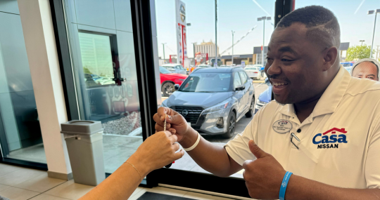 Man handing keys to woman for new Nissan vehicle at Casa Nissan